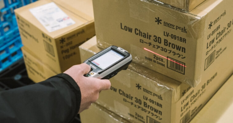ハンディ機器を使い荷物を検品する人