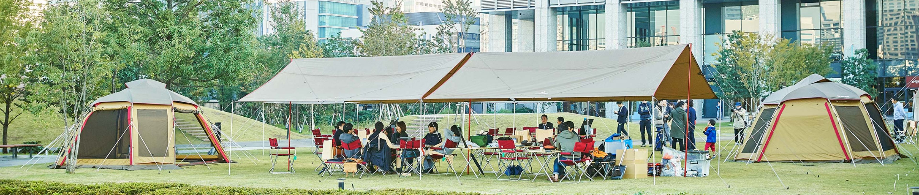 野外でテントを設置して研修をする人々