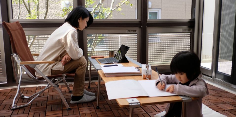 在宅勤務をする親と隣で勉強する子供
